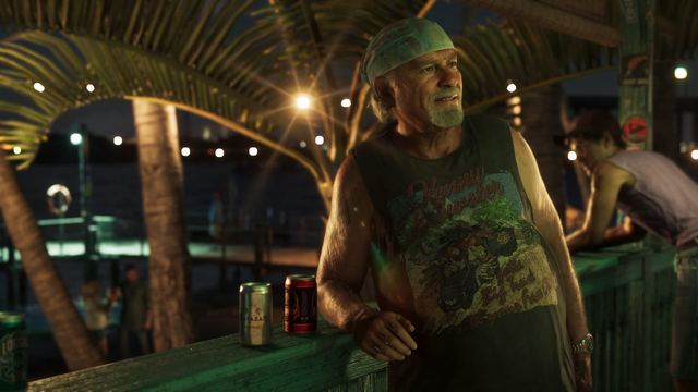 Brian leaning against a railing with two cans in front of him. He is wearing a sleevless shirt and a bandana.