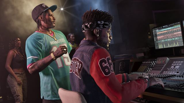 People gathered in a recording studio. A man is sitting in the foreground in front of equipment and Dre'Quan stands directly next to him.