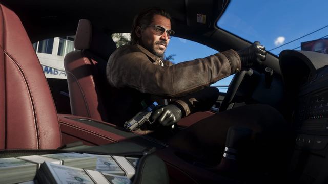 Raul driving with one hand and holding a handgun hidden with the other. A bag full of cash sits open next to him in the passenger seat.